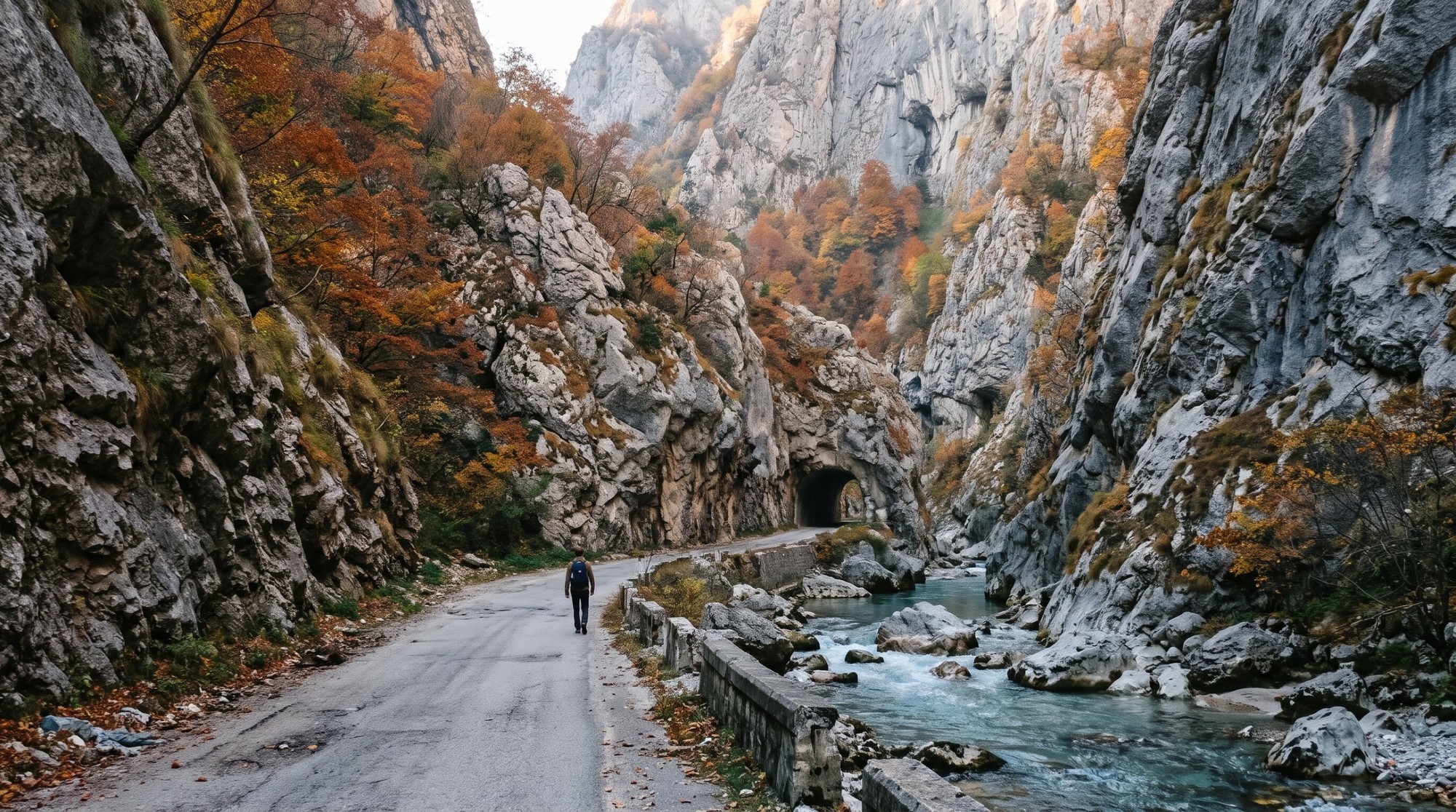 🇽🇰 تكلفة السفر إلى كوسوفو 2026: ميزانية 7 أيام من مصر بالجنيه واليورو 8 مسافر لوحده ماشي على الطريق الضيق في وادي روجوفا قرب بيا جنب النهر الفيروزي وقدامه نفق محفور في الصخر